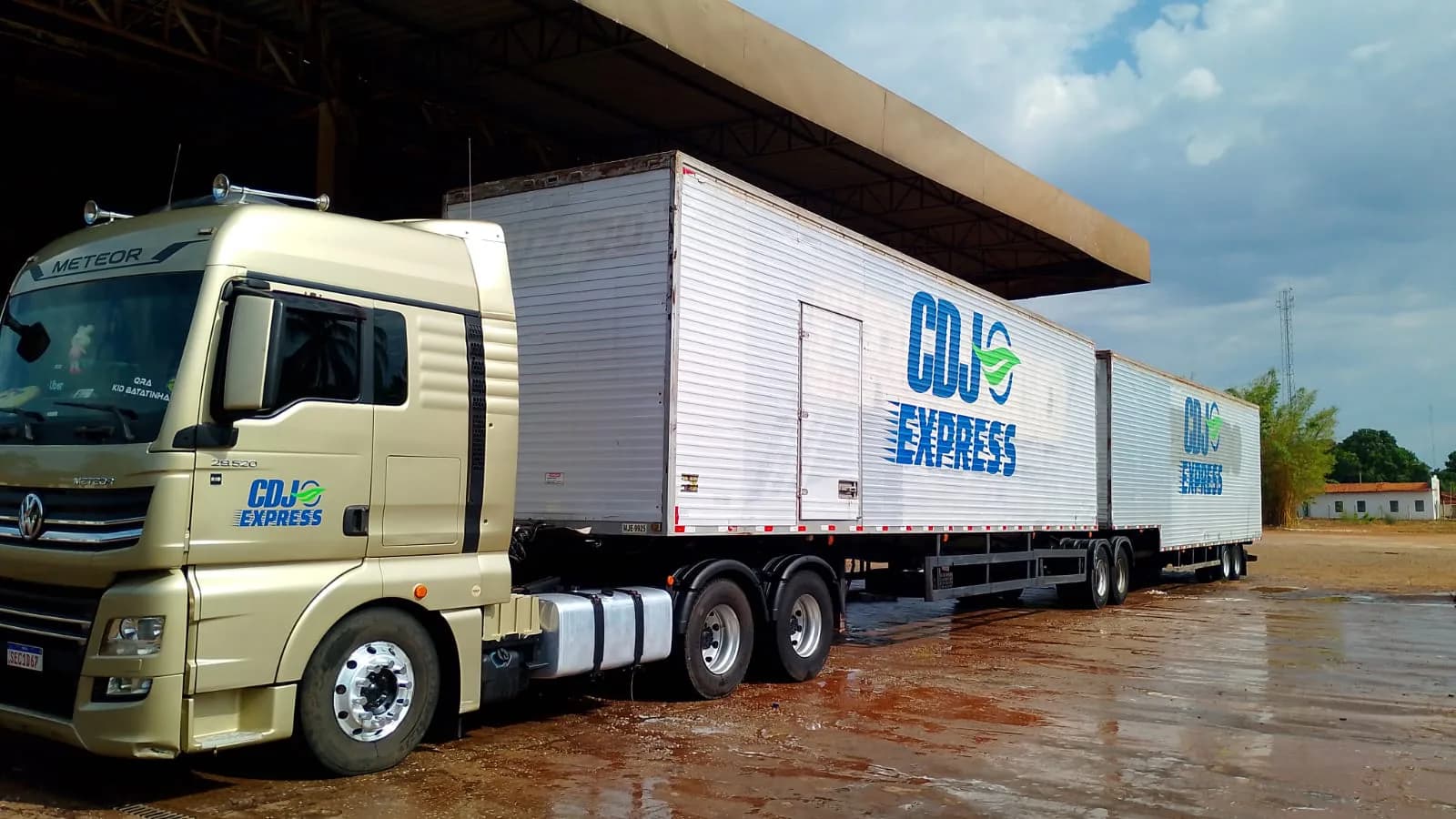 Caminhão da CDJ Express com dois implementos estacionado no pátio